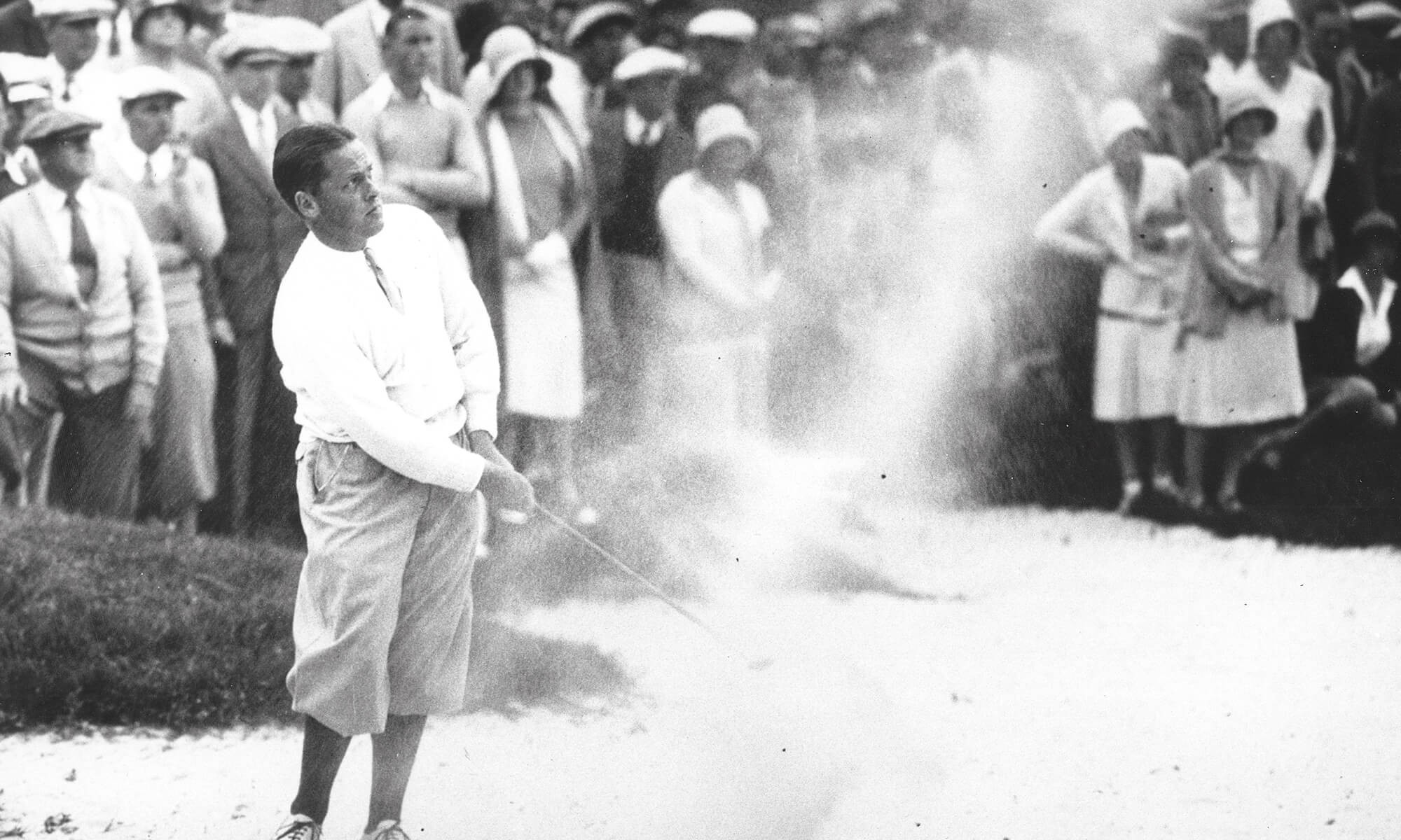 Man hitting golf ball out of sand trap