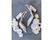 White Jimmy Choo heels displayed with white flowers and wedding rings in ring dishes