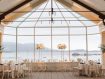 The Beach and Tennis Club dining room set for a wedding with long head table and tall flower arrangements