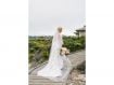 A bride at Spanish Bay with long veil and bouquet.