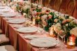 Wedding table setting with pink tablecloth and floral garland