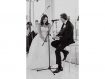 Black and white photo with father of the bride playing guitar to smiling bride