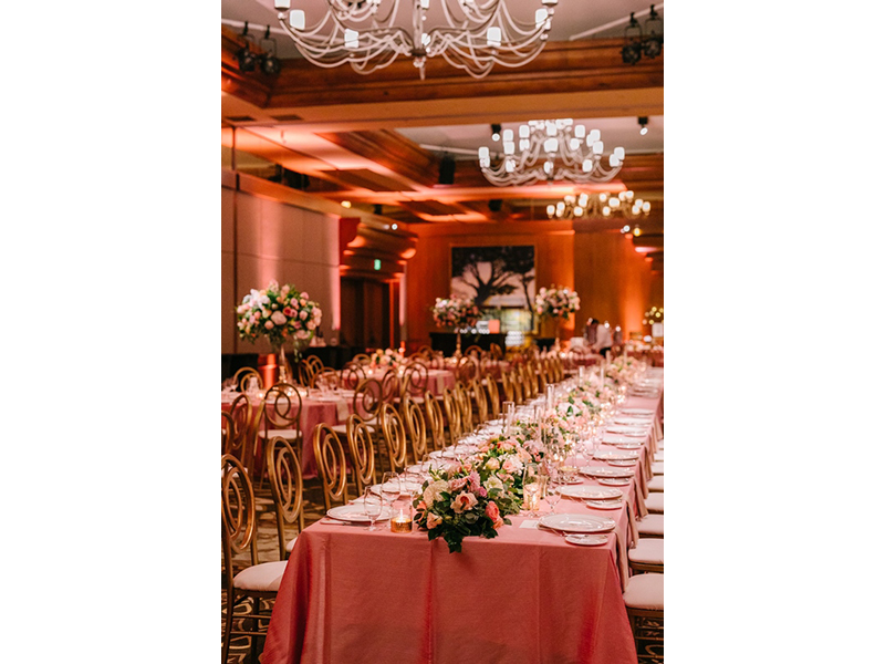 Spanish Bay ballroom set up for wedding reception with pink tablecloths and florals