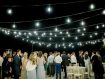 Beach & Tennis Club patio at night with market lights and wedding attendees