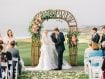 Bride and groom with ceremony arch at Spanish Bay