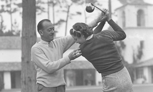 Man instructing woman on golf swing